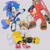 Size: 2048x2048 | Tagged: safe, artist:mossan315, knuckles the echidna, miles "tails" prower, sonic the hedgehog, echidna, fox, hedgehog, alternate outfit, clenched fist, crossover, eyewear on head, goggles, grey background, grin, headphones, holding something, paintbrush, simple background, smile, splatoon, standing, sunglasses, team sonic, trio