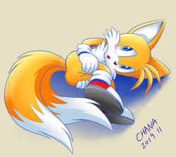 Size: 1175x1049 | Tagged: safe, artist:tailchana, miles "tails" prower, 2020, :o, beige background, blushing, butt, cute, hands on own legs, looking up, lying on side, modern tails, mouth open, shadow (lighting), signature, simple background, solo, tailabetes