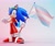Size: 2048x1728 | Tagged: dead source, safe, artist:ladylunanova, sonic the hedgehog, 2024, 3d, crop top, crystal ring, flag, gradient background, holding something, looking at viewer, pants, pride, pride flag, smile, solo, sunglasses, trans female, trans pride, trans visibility day, transgender