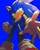Size: 1048x1302 | Tagged: safe, artist:brushteethjaxx, sonic the hedgehog, hedgehog, blue background, clenched fist, from below, grin, lidded eyes, looking at viewer, male, reaching out, reaching towards the viewer, simple background, smile, solo, standing