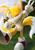 Size: 2480x3508 | Tagged: safe, artist:井上くと, miles "tails" prower, 2021, absurd res, clenched fist, daytime, faux 3d, fist, grass, lineless, looking at viewer, outdoors, reflection, smile, smiling at viewer, solo, standing, standing on one leg, treads, tree, v sign, wink, winking at viewer